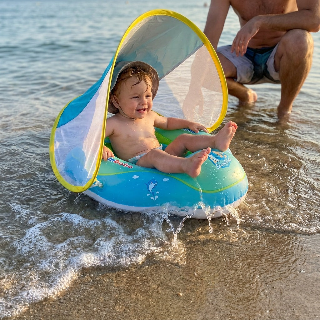 Bébé dans la bouée AquaCocon au bord de la mer