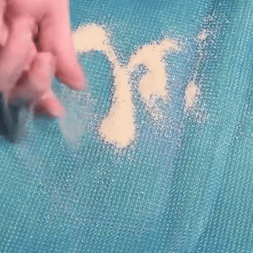 Le sable versé sur la maille disparaît d'un revers de main